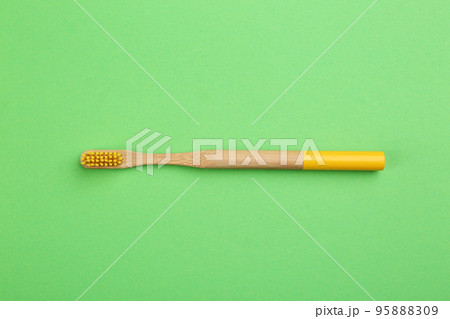 Natural bamboo toothbrush on green background, top view Natural bamboo toothbrush on green background, top view 95888309