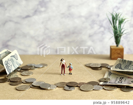 手をつなぐ女性と女の子の人形と周囲にお金 手をつなぐ女性と女の子の人形と周囲にお金 95889642