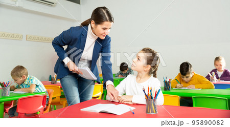 Teacher woman helping children during lesson 95890082