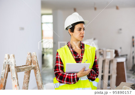Woman engineer checking documents during repair works 95890157