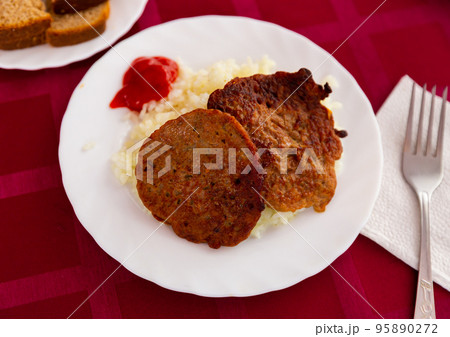 Boiled rice with two meat cutlets and ketchup 95890272