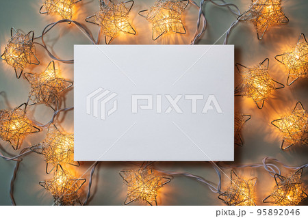 Christmas winter festive ornament. Blank paper card and Christmas lights decoration background. Invitation Christmas holiday party. Christmas winter festive ornament. Blank paper card and Christmas lights decoration background. Invitation Christmas holiday party. 95892046