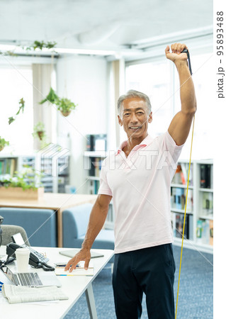 デスクワーク中に筋トレをするビジネスマン 95893488