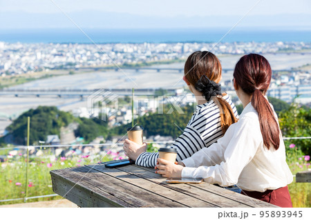 町の景色を眺める若い女性二人 95893945