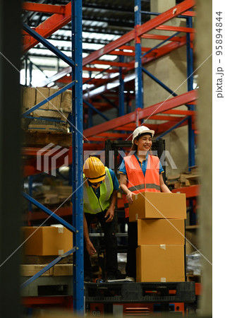 Warehouse workers working in the retail warehouse full of shelves with goods. Manufacture storehouse occupation concept 95894844