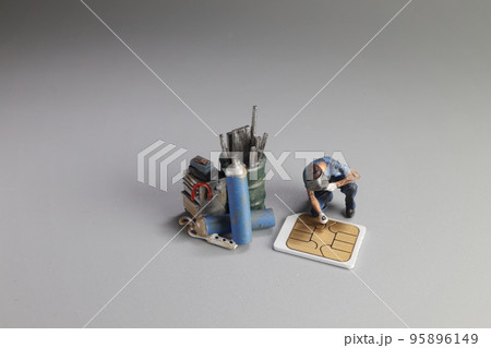 a Damaged sim card and miniature figure model scene. 95896149