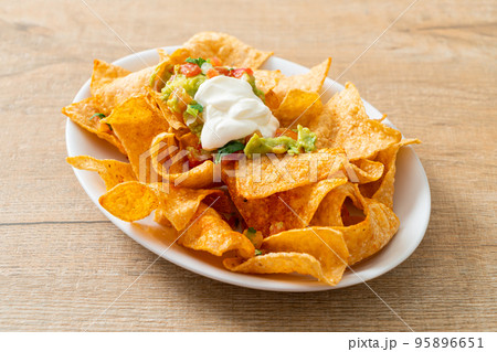 nachos tortilla chips with jalapeno, guacamole, tomatoes salsa and dip nachos tortilla chips with jalapeno, guacamole, tomatoes salsa and dip 95896651