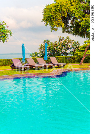 chair pool and umbrella around swimming pool 95896890