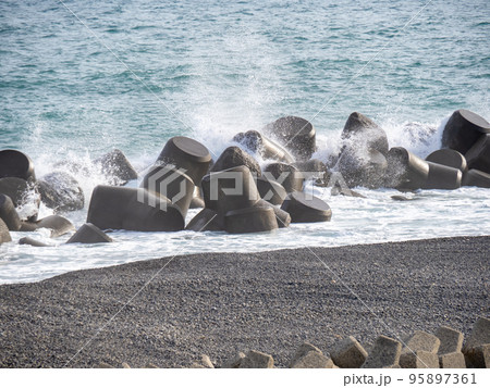 海岸の消波ブロックに荒波が打ち寄せて波しぶきが上がる。 海岸の消波ブロックに荒波が打ち寄せて波しぶきが上がる。 95897361