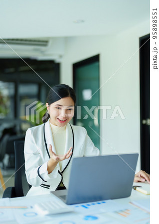 A portrait of a female employee using a computer video conferencing to discuss work through the Internet network. 95898551