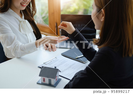 Accountant, businessman, real estate agent, Asian business woman handing keys to customers along with house after customers to sign. Accountant, businessman, real estate agent, Asian business woman handing keys to customers along with house after customers to sign. 95899217
