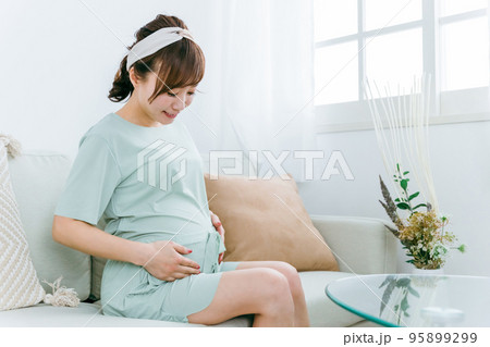 家でソファに座る笑顔の妊婦(アジア人女性) 家でソファに座る笑顔の妊婦(アジア人女性) 95899299