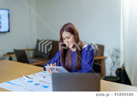 Portrait of a young Asian woman working at home via the Internet.. 95899380