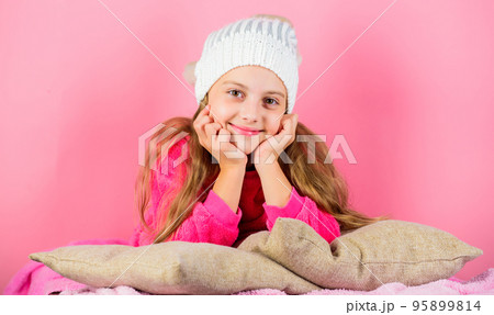 Winter fashion accessory. Kid girl knitted hat. Winter accessory concept. Girl long hair dream pink background. Kid dreamy lean on pillows. Winter season coziness attribute. Winter season concept 95899814