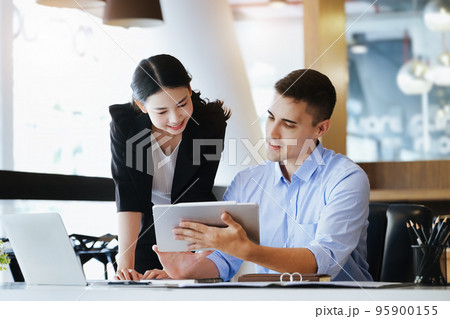 The male marketing manager expressed his satisfaction in selling the company's products. where team members show sales from their iPad screen 95900155