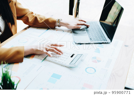 financial, Planning, Marketing and Accounting, portrait of Asian employee checking financial statements using documents and calculators at work.. financial, Planning, Marketing and Accounting, portrait of Asian employee checking financial statements using documents and calculators at work.. 95900771