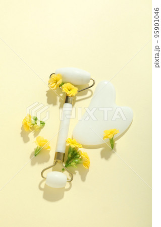 Lifting and toning treatment concept with gua sha and face roller with flowers Lifting and toning treatment concept with gua sha and face roller with flowers 95901046