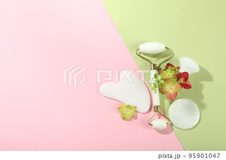 Lifting and toning treatment concept with gua sha on two tone background Lifting and toning treatment concept with gua sha on two tone background 95901047