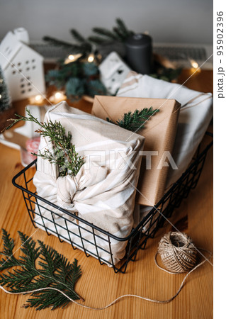Christmas Furoshiki Japanese Fabric Wrapping gifts. Xmas Zero waste reusable eco friendly sustainable Christmas gift wrapping in linen fabric on table at home Christmas Furoshiki Japanese Fabric Wrapping gifts. Xmas Zero waste reusable eco friendly sustainable Christmas gift wrapping in linen fabric on table at home 95902396
