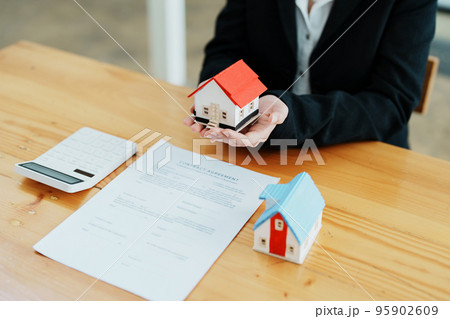 Guarantee, mortgage, agreement, contract, sign, real estate agent delivers the house to the customer after signing important contract documents. Guarantee, mortgage, agreement, contract, sign, real estate agent delivers the house to the customer after signing important contract documents. 95902609