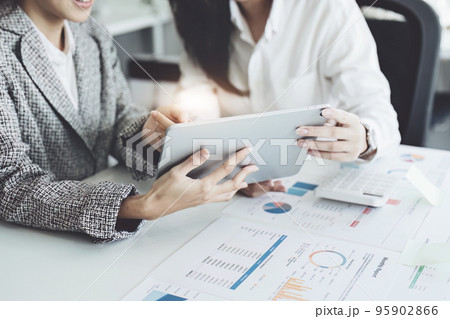 young Asian businesswoman using tablet computers to plan marketing strategies and invest to profit from customers. 95902866
