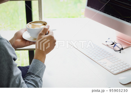 Work from home A company employee holding a coffee cup using a computer to work from home to prevent coronavirus from meeting outsiders Work from home A company employee holding a coffee cup using a computer to work from home to prevent coronavirus from meeting outsiders 95903230