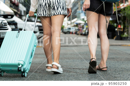 Two travelers with backpacks and bags, taken from behind. Two travelers with backpacks and bags, taken from behind. 95903250