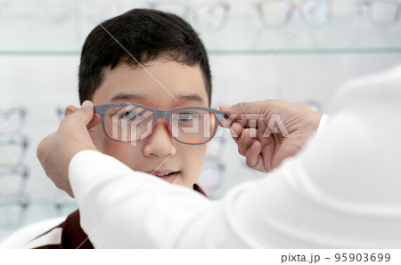 Boy has his eyes checked for glasses by a specialist. Boy has his eyes checked for glasses by a specialist. 95903699