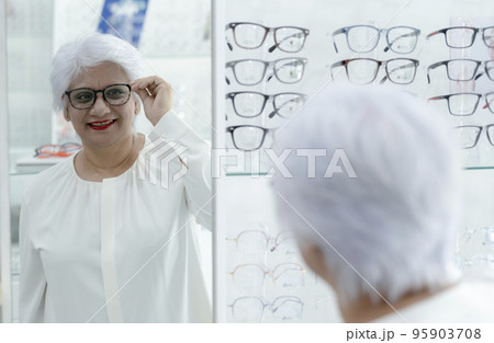 Elderly woman trying on new glasses. Elderly woman trying on new glasses. 95903708