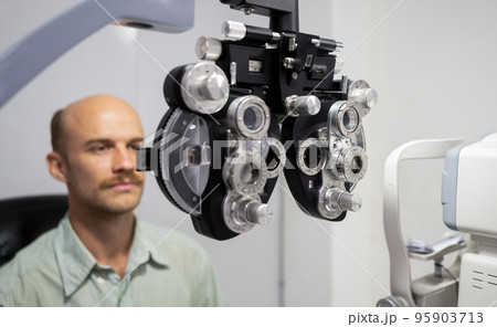 Young man checking his eyes to make glasses. Young man checking his eyes to make glasses. 95903713