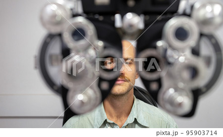 Young man checking his eyes to make glasses. Young man checking his eyes to make glasses. 95903714
