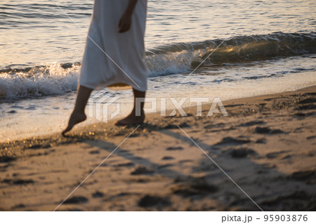 夕焼けの浜辺を歩く女性 夕焼けの浜辺を歩く女性 95903876