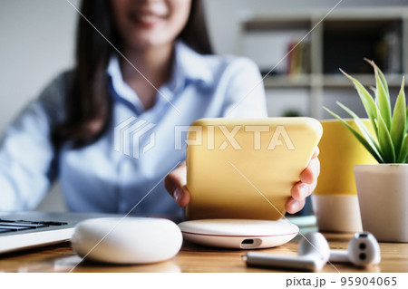 focus Female hand holding Smartphone to Charging at Wireless fast Charging pad at work. vintage tone focus Female hand holding Smartphone to Charging at Wireless fast Charging pad at work. vintage tone 95904065