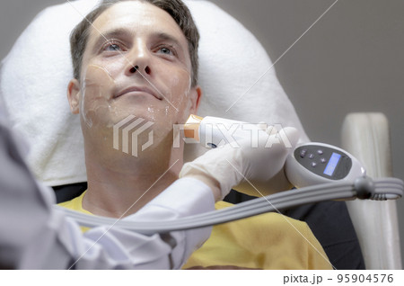 White man is removing wrinkles and rejuvenating facial skin by a specialist doctor 95904576