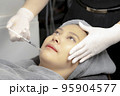 Experts perform injections for chin augmentation and anti-aging facials on young women, beauty clinics. 95904577