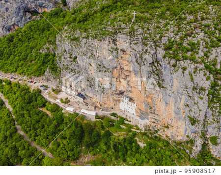 Monastery of Ostrog, Serbian Orthodox Church situated against a vertical background, high up in the large rock of Ostroska Greda, Montenegro. Dedicated to Saint Basil of Ostrog 95908517