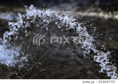 Water splashing from the fountain, jet, aqua drops, clear liquid splash on dark background Water splashing from the fountain, jet, aqua drops, clear liquid splash on dark background 95908793