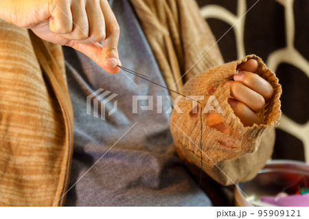 Mending clothes, sustainable fashion ethical consumerism concept, repair, recycle, reuse clothes. Selective focus Mending clothes, sustainable fashion ethical consumerism concept, repair, recycle, reuse clothes. Selective focus 95909121