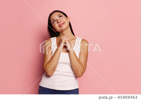 Happy woman with dreams smiling isolated on trendy pink studio background. Beautiful female half-length portrait. Emotional woman. Human emotions, facial expression concept 95909463