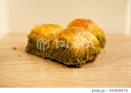 Baklava with pistachio, one of the most beautiful desserts of Turkish cuisine, on oak cutting board 95909678