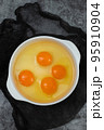 few yellow egg yolks in a white bowl 95910904