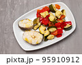 baked vegetables with boiled fish on white plate 95910912
