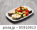 baked vegetables with boiled fish on white plate 95910913