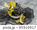 Fresh Dark blue purple grape in plate on grey background. 95910917