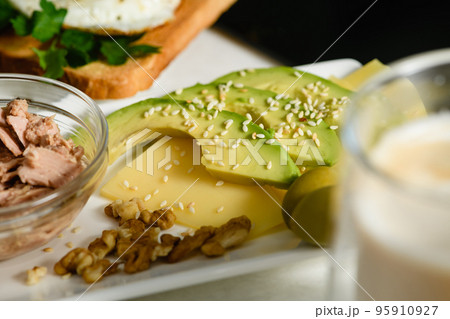 Appetizing avocado slices with sesame seeds on cheese. Morning breakfast. 95910927