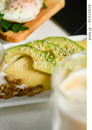 Appetizing avocado slices with sesame seeds on cheese. Morning breakfast. 95910928