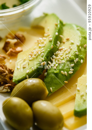 Appetizing avocado slices with sesame seeds on cheese. Morning breakfast. 95910929