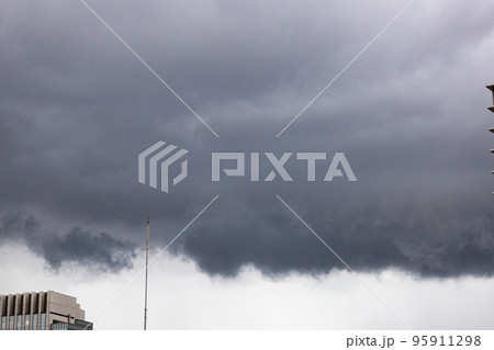都会の秋の空・竜巻が発生しそうな嵐の雨雲が広がる空と避雷針と都会のビル（東京都千代田区） 95911298