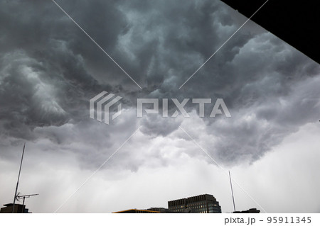 都会の秋の空・竜巻が発生しそうな嵐の雨雲が広がる空と避雷針とビル（東京都千代田区） 95911345