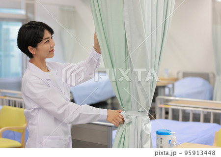 ベッドを囲むカーテンを閉めようとする看護士1 ベッドを囲むカーテンを閉めようとする看護士1 95913448